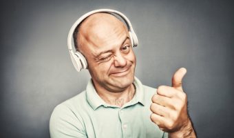 man listening to music on headphones, shows ok,