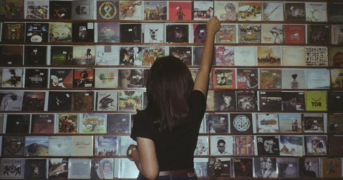 Girl looking at a wall of CDs