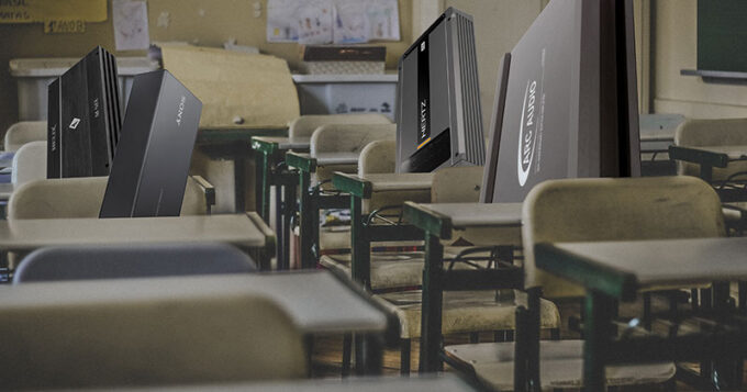 Various amplifiers sitting in chairs at school desks in a classroom
